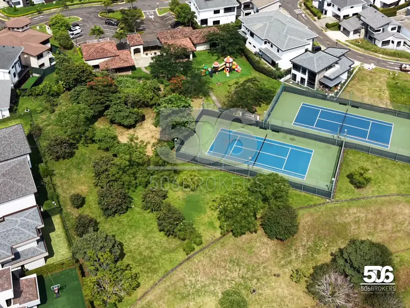 Vista aérea del condominio Francosta con canchas de tenis y áreas verdes